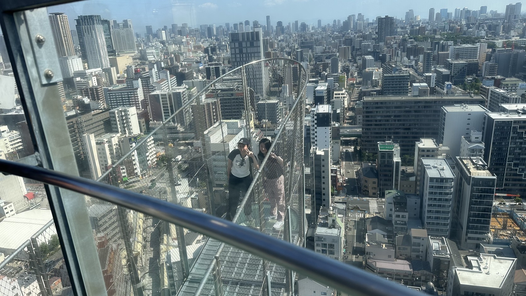 從突出的透明平台往下看到的街道與欄杆