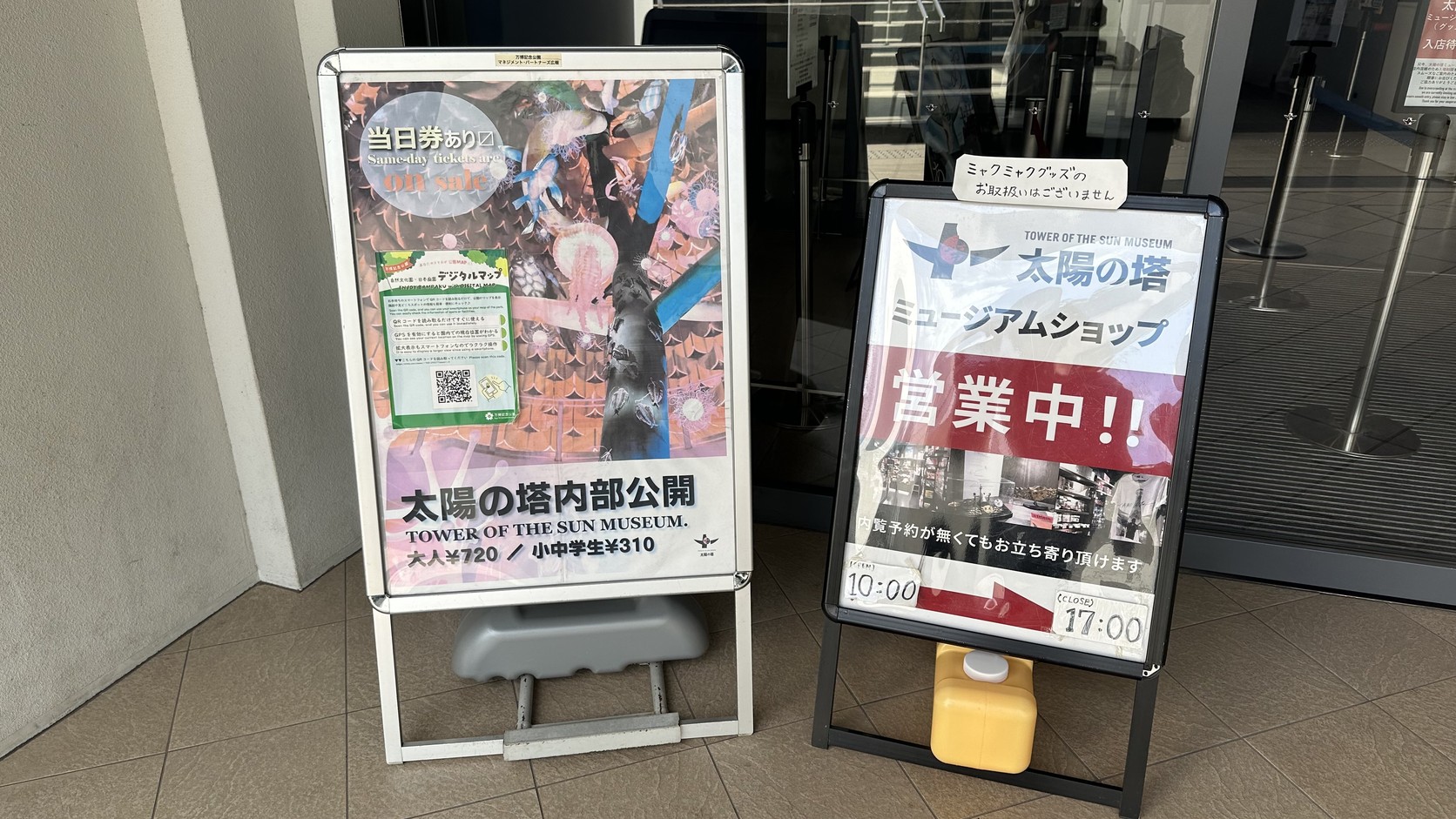 太陽之塔入口立牌，寫著「当日券あり」與成人 720 日圓、中小學生 310 日圓