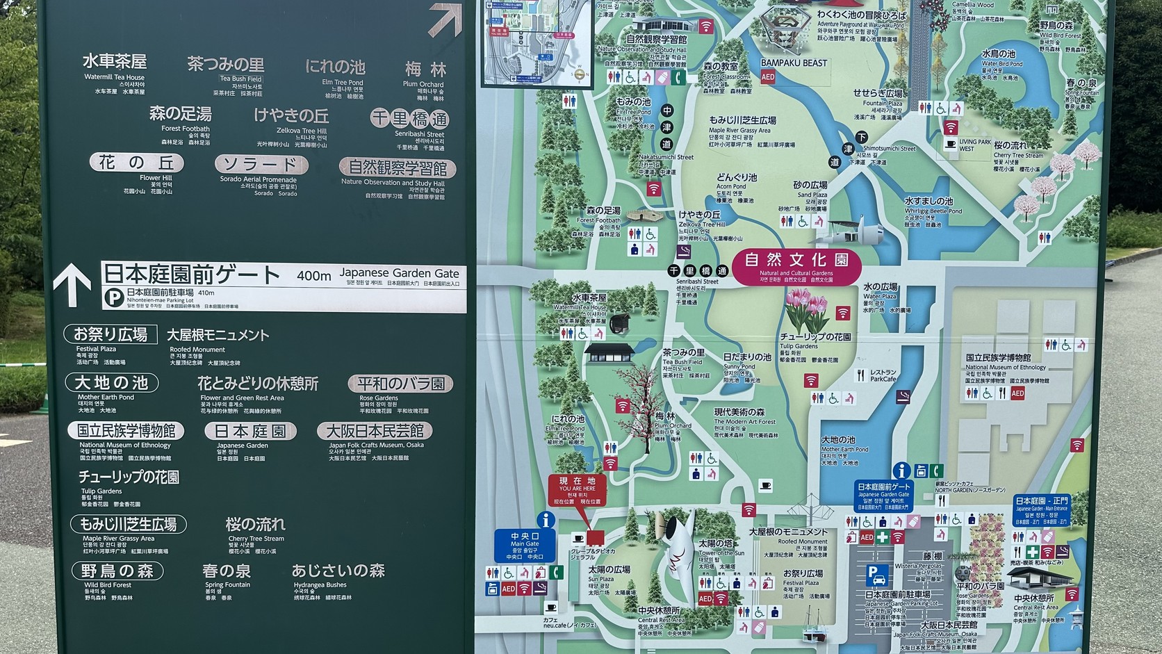 園內的綠底導覽看板，列出園內各景點名稱與前往日本庭園前門的方向