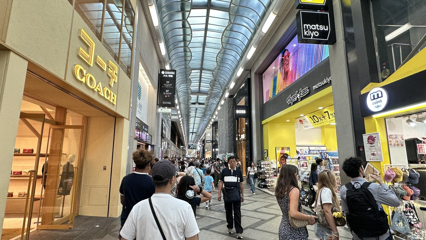 有拱形棚蓋的心齋橋筋商店街縱深，左側是COACH店面