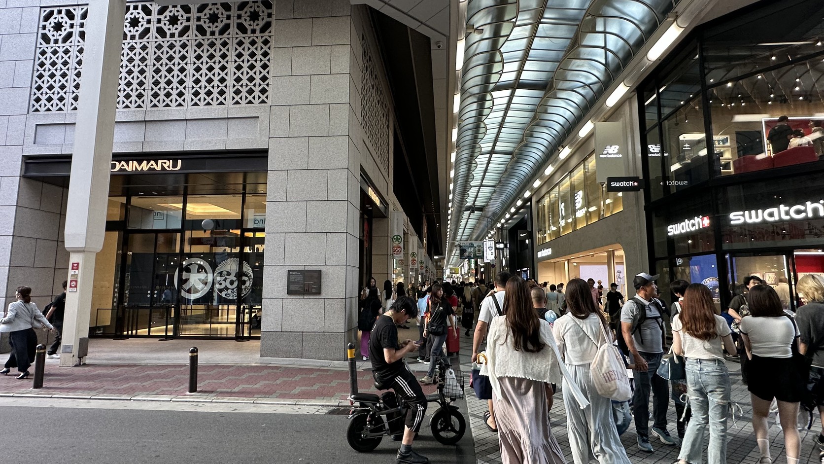 心齋橋筋商店街旁的大丸心齋橋店入口，右側可見New Balance與Swatch
