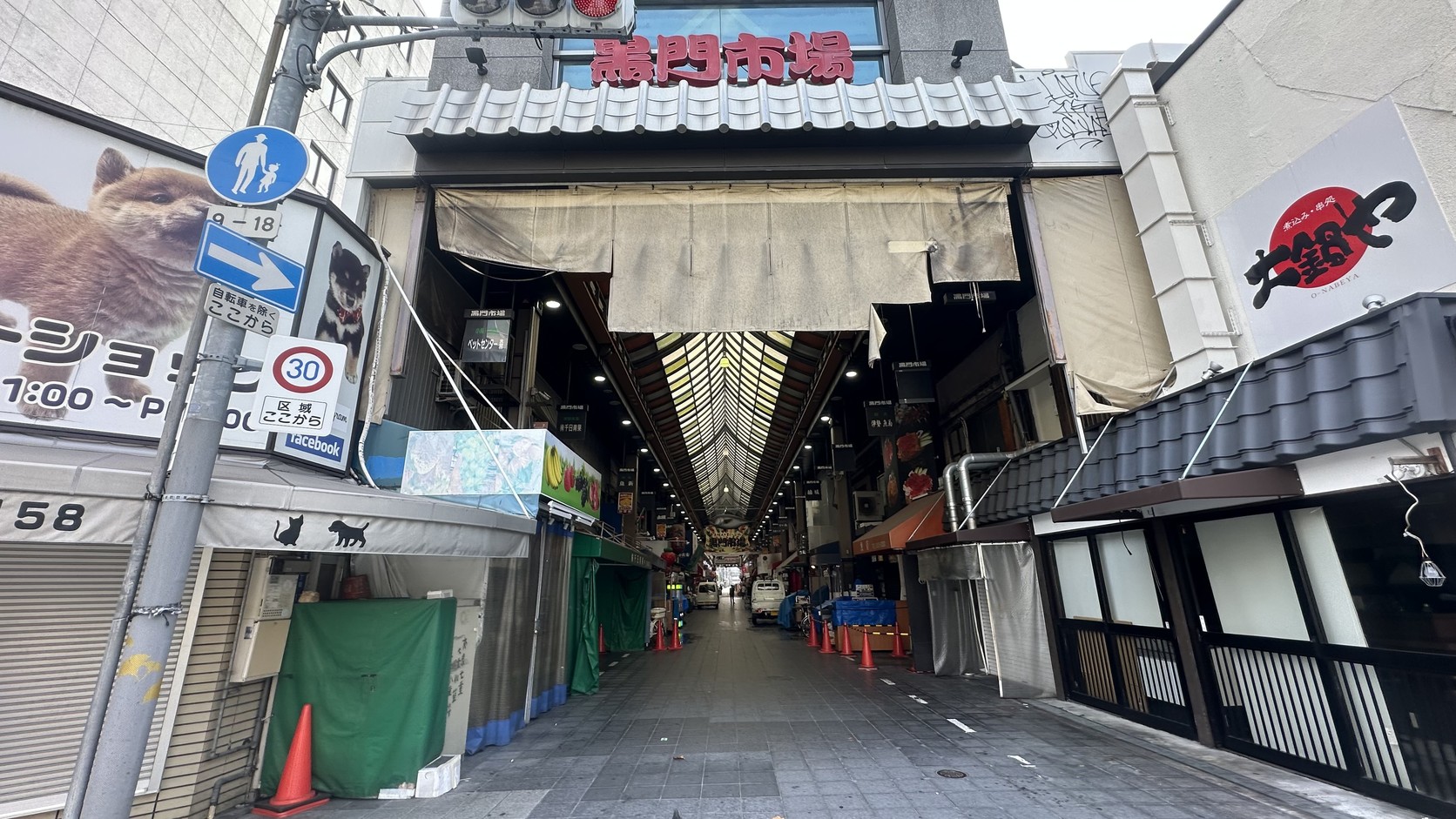 黑門市場入口的有頂拱廊與市場招牌，清晨多數店家仍拉下鐵門