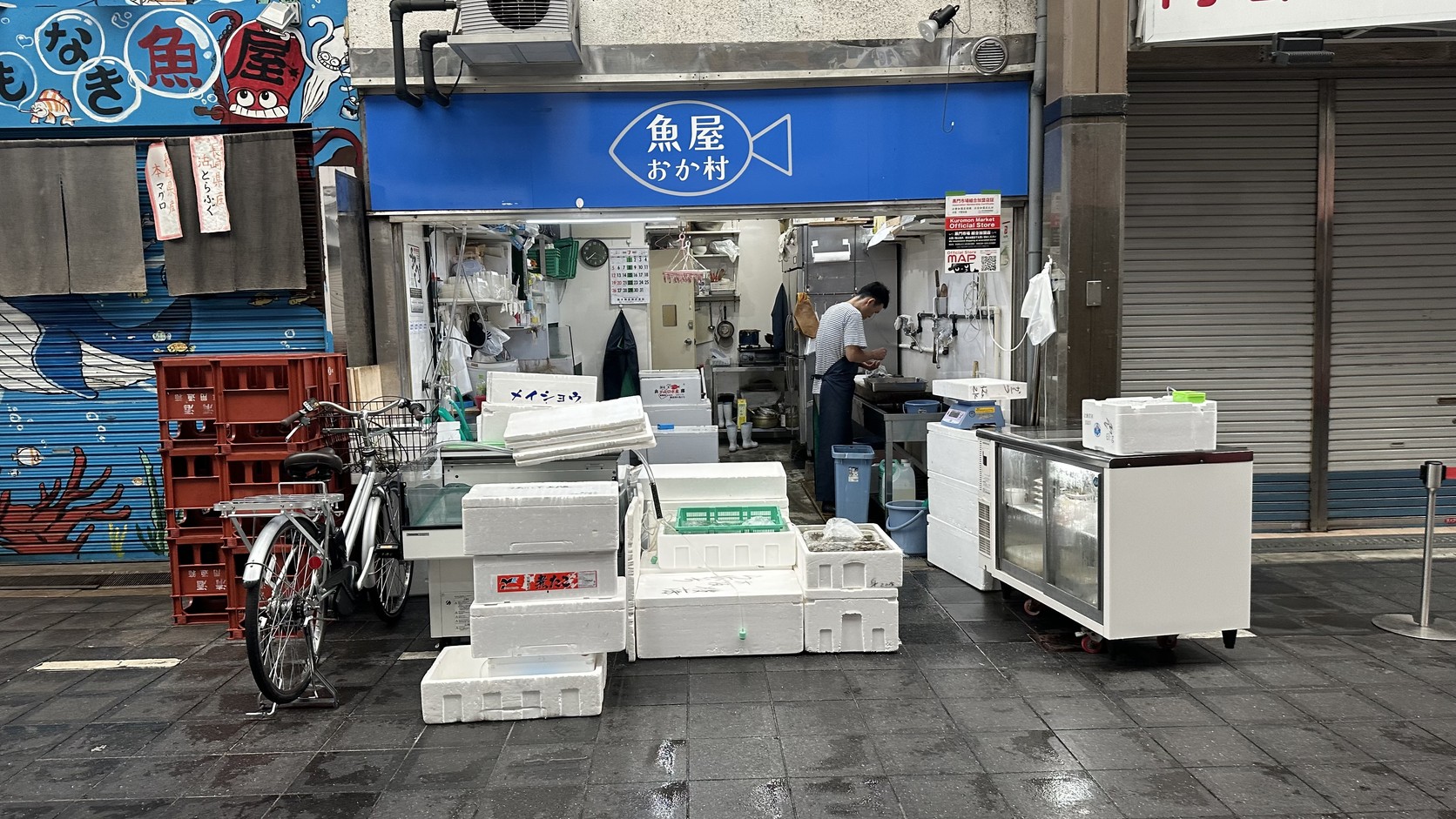 魚店門口堆著保麗龍箱，店內店員正在備貨