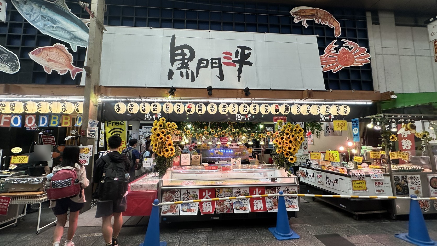 約 8 點的黑門三平店面，向日葵裝飾、海鮮展示櫃與黃色價目牌都已擺出來