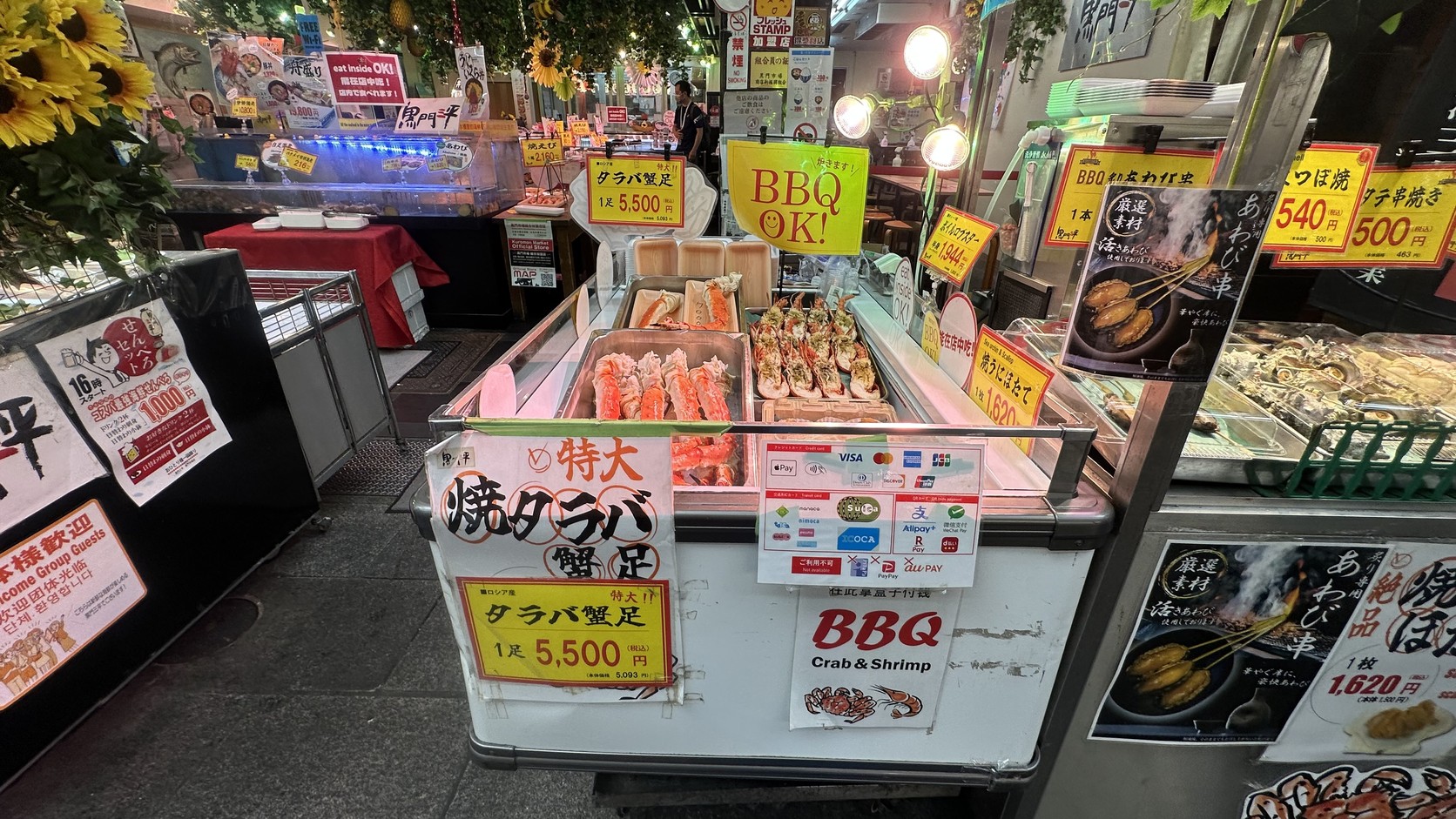 黑門三平的帝王蟹腳價目牌，旁邊立著標示可用支付方式的牌子