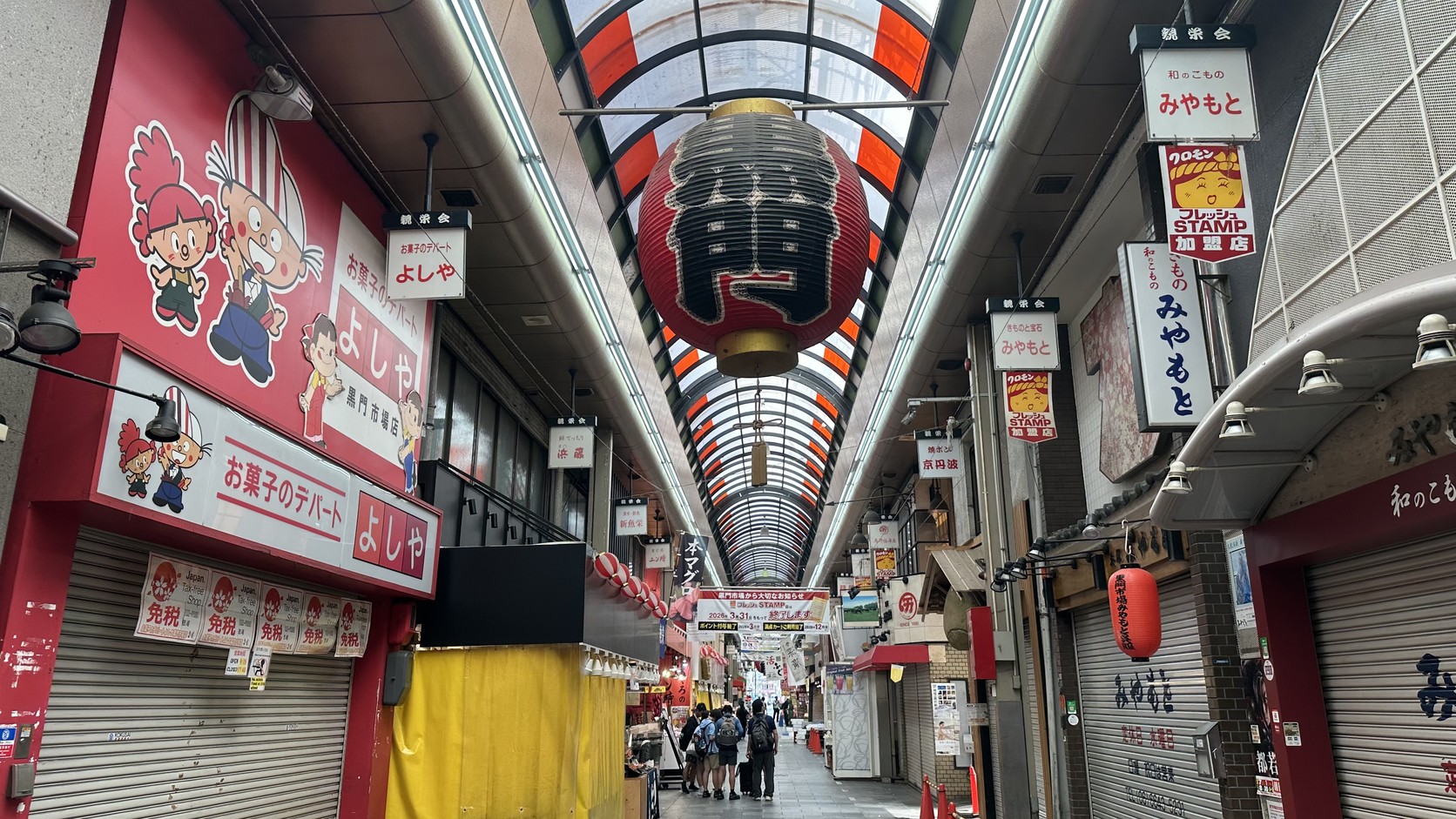 清晨黑門市場的長拱廊與紅色大燈籠，遠處只有零星行人