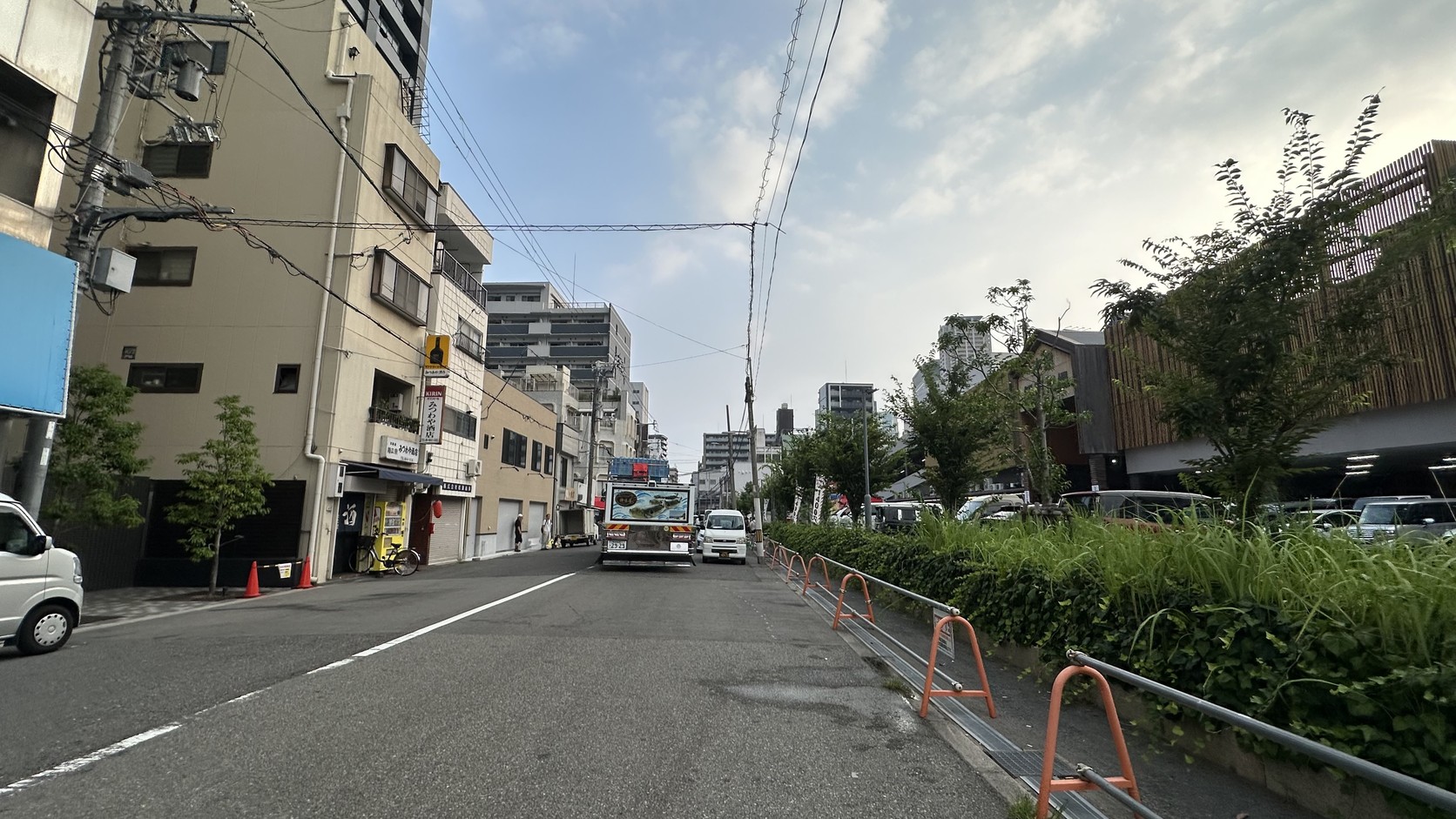 清晨的市場周邊街道，路旁有住宅與停放的車輛