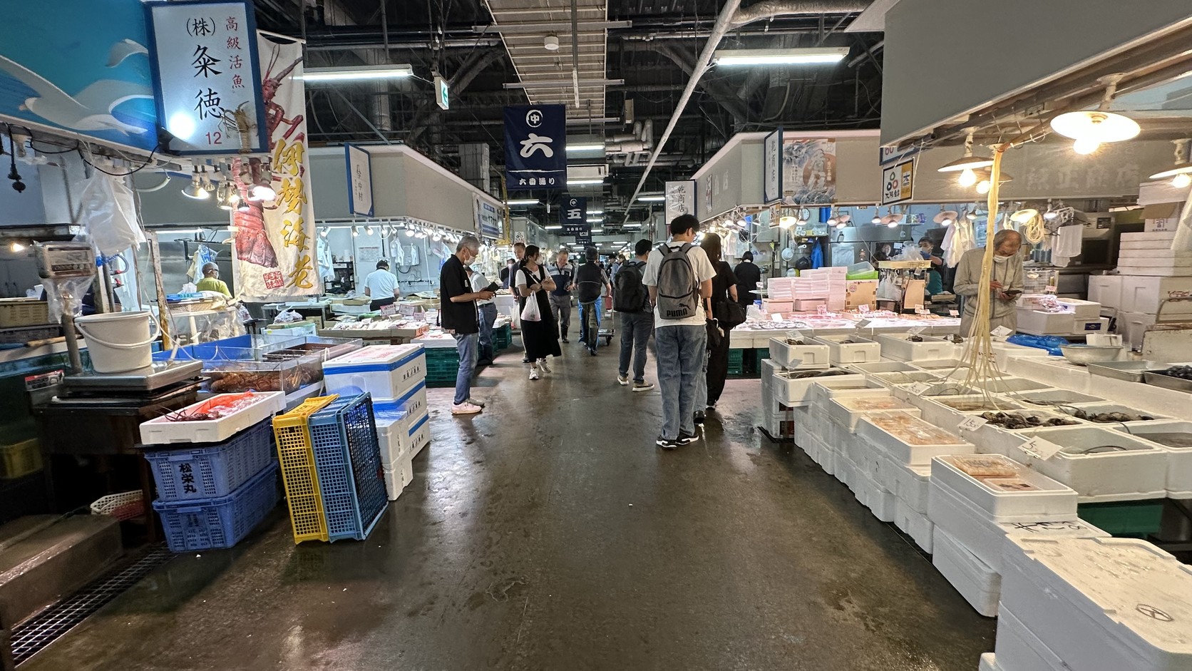 市場通道上的五番通與六番通吊牌，通道兩側是魚貨攤位