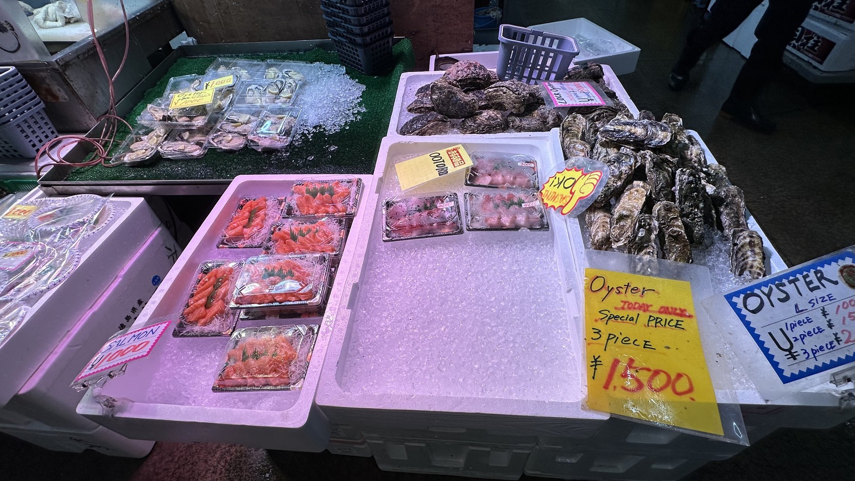 攤位上擺放的生蠔與鮭魚片，價牌以英文寫著 Oyster 與 Special Price