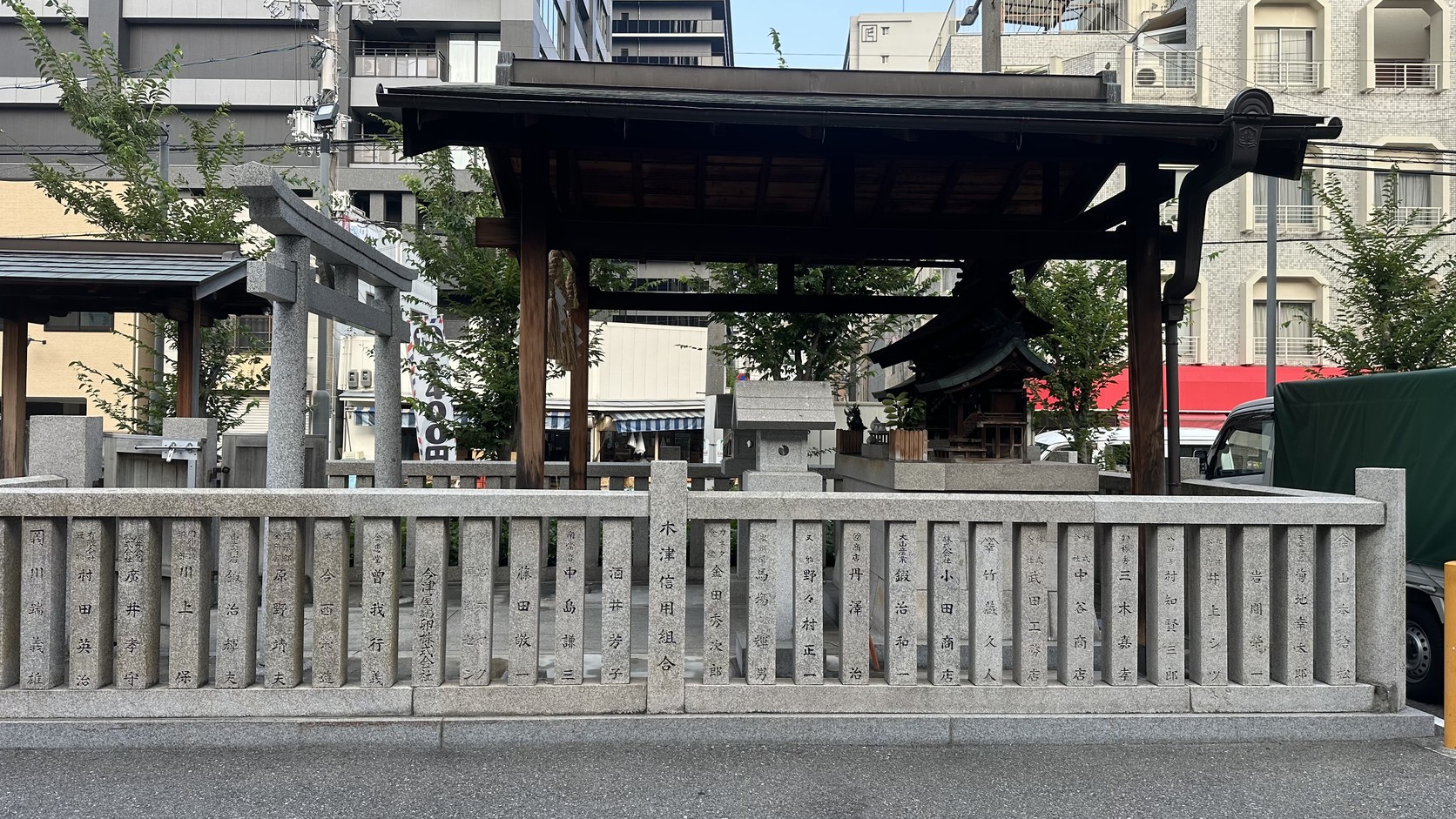 市場入口旁的鳥居與神社，前方是石造欄杆
