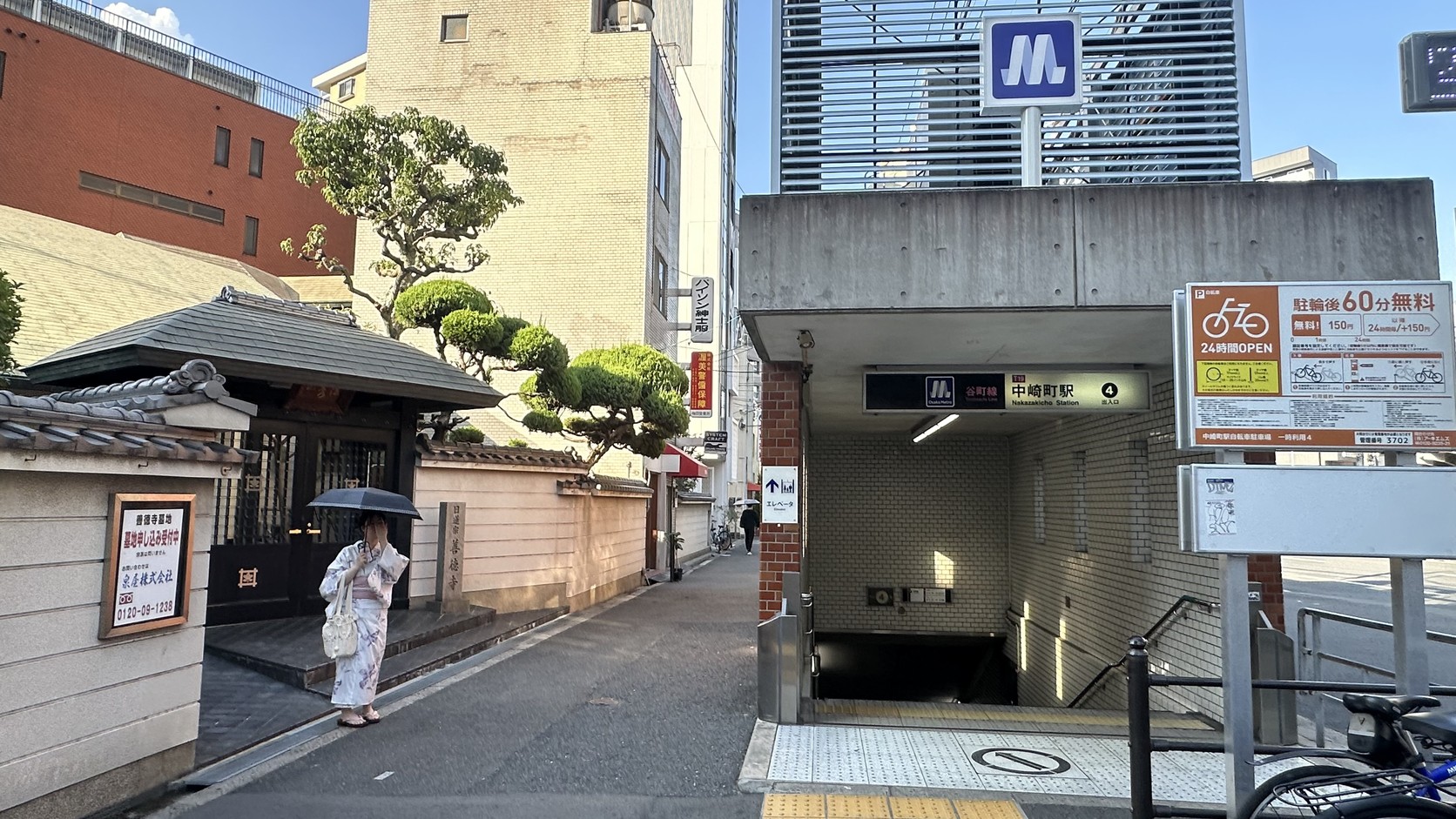 中崎町站4號出口旁的善德寺山門與瓦屋頂圍牆，後方是現代大樓