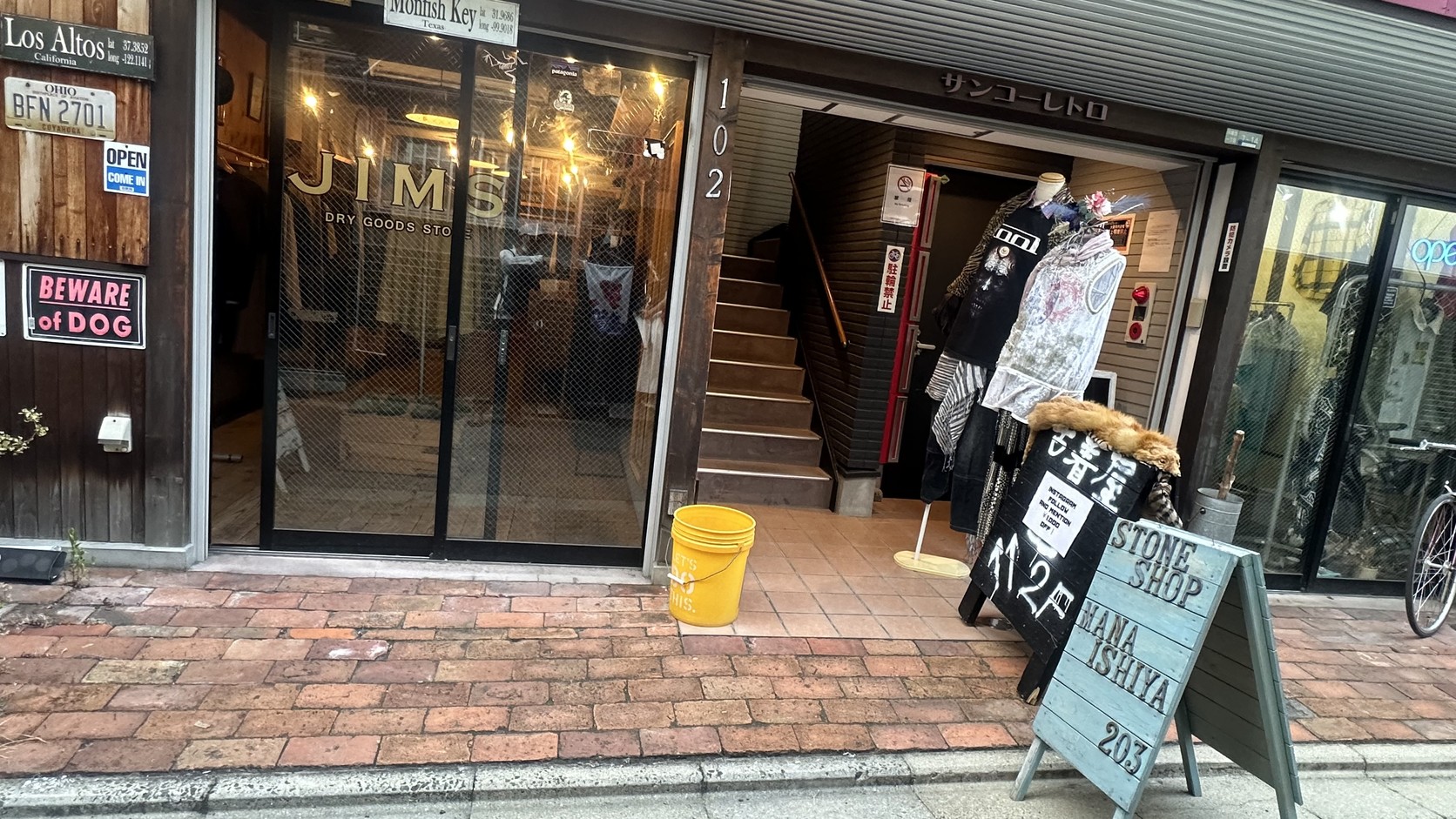 立著「古着屋」立牌的店家入口與「JIMS DRY GOODS STORE」招牌