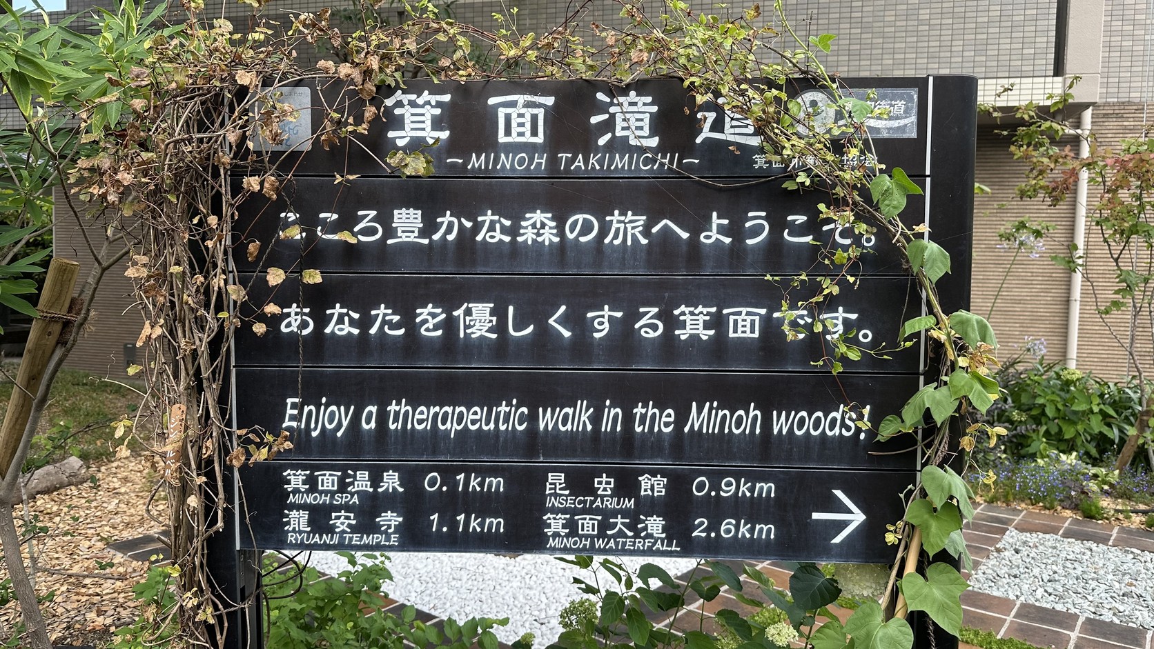 瀧道入口的「箕面滝道」指示牌，標示箕面溫泉 0.1、昆蟲館 0.9、瀧安寺 1.1、箕面大滝 2.6 公里