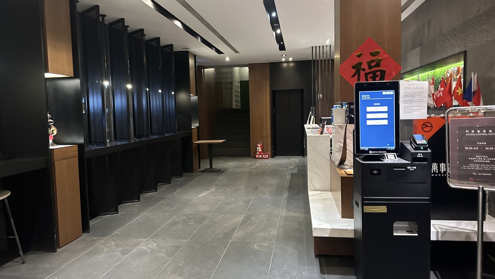 萬事達行旅大廳全景，自助入住機台與接待櫃檯實拍