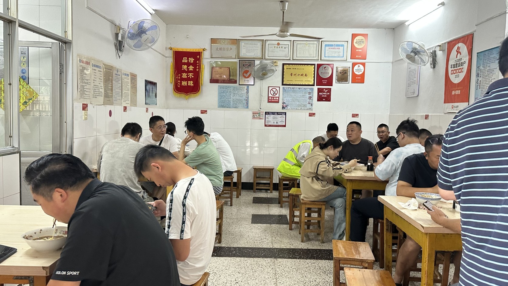 盛興麵館店內用餐空間與牆面獎牌實拍，可見常州十碗面牌匾與MICHELIN 2026牌