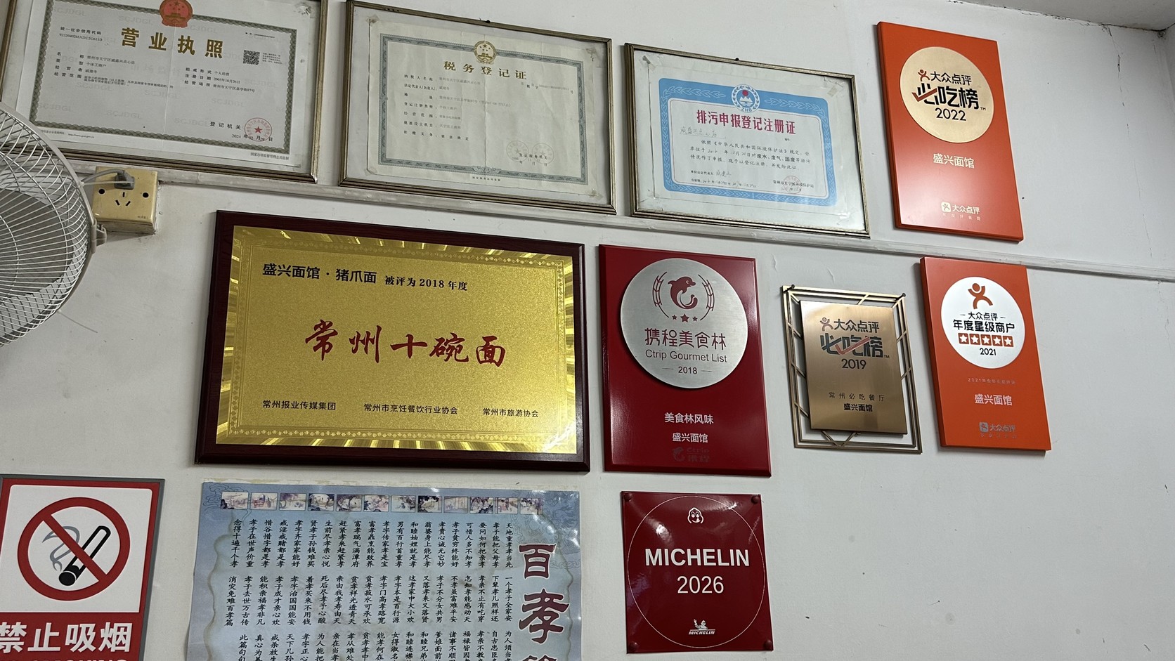 盛興麵館牆面獎牌近拍：2018常州十碗面豬爪面牌匾、攜程美食林2018、大眾點評必吃榜與MICHELIN 2026
