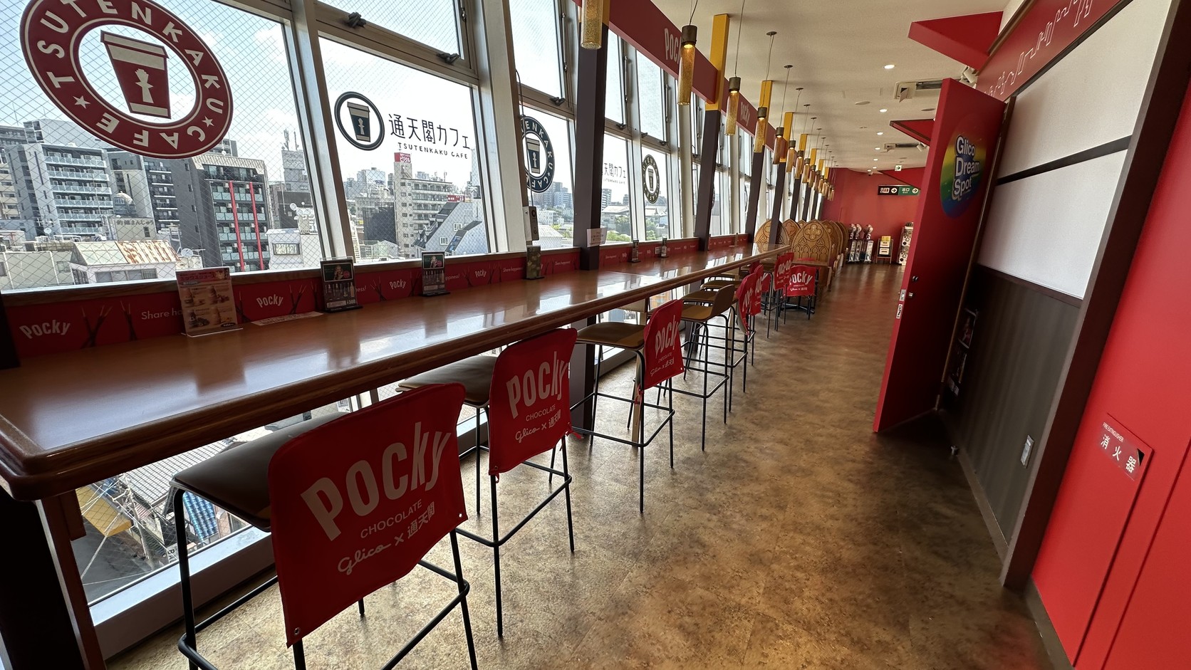 通天閣咖啡座位的窗邊長桌，椅背做成 Pocky 包裝的樣子，標示「Glico × 通天閣」