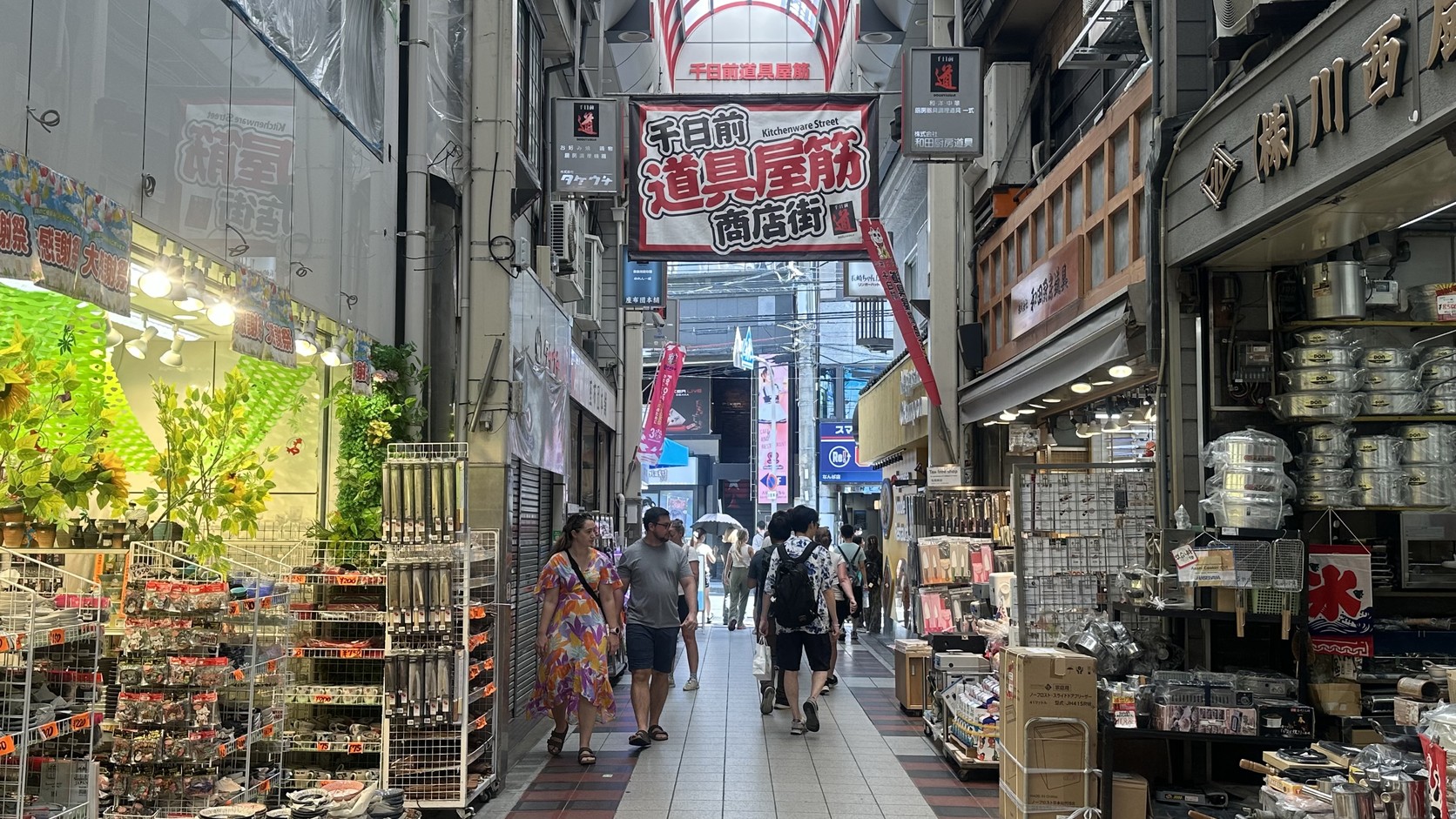 千日前道具屋筋商店街拱廊內的紅色「千日前 道具屋筋 商店街」大招牌，兩側是食器與廚房用品店