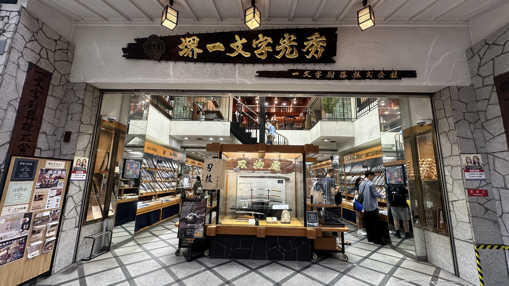堺一文字光秀刀具專門店的店面，金色招牌下是多層樓的刀具陳列櫃