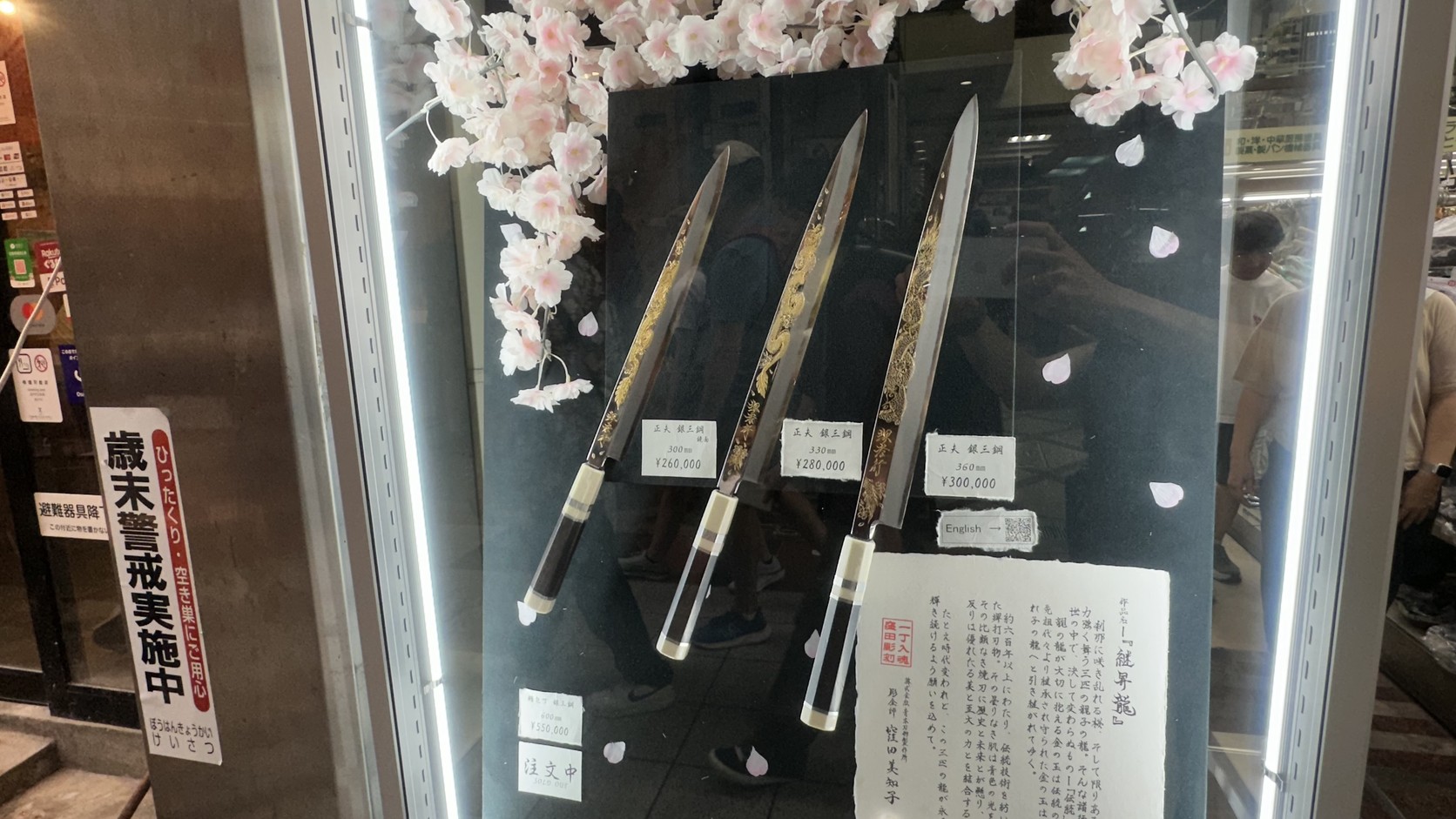 三把雕有金色龍紋與花紋的長刀並排展示，價牌標示銀三鋼 300mm ¥260,000、330mm ¥280,000、360mm ¥300,000