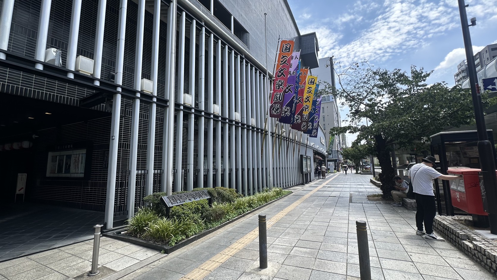 國立文樂劇場外觀，白色直柱立面、入口與沿街的彩色幟旗