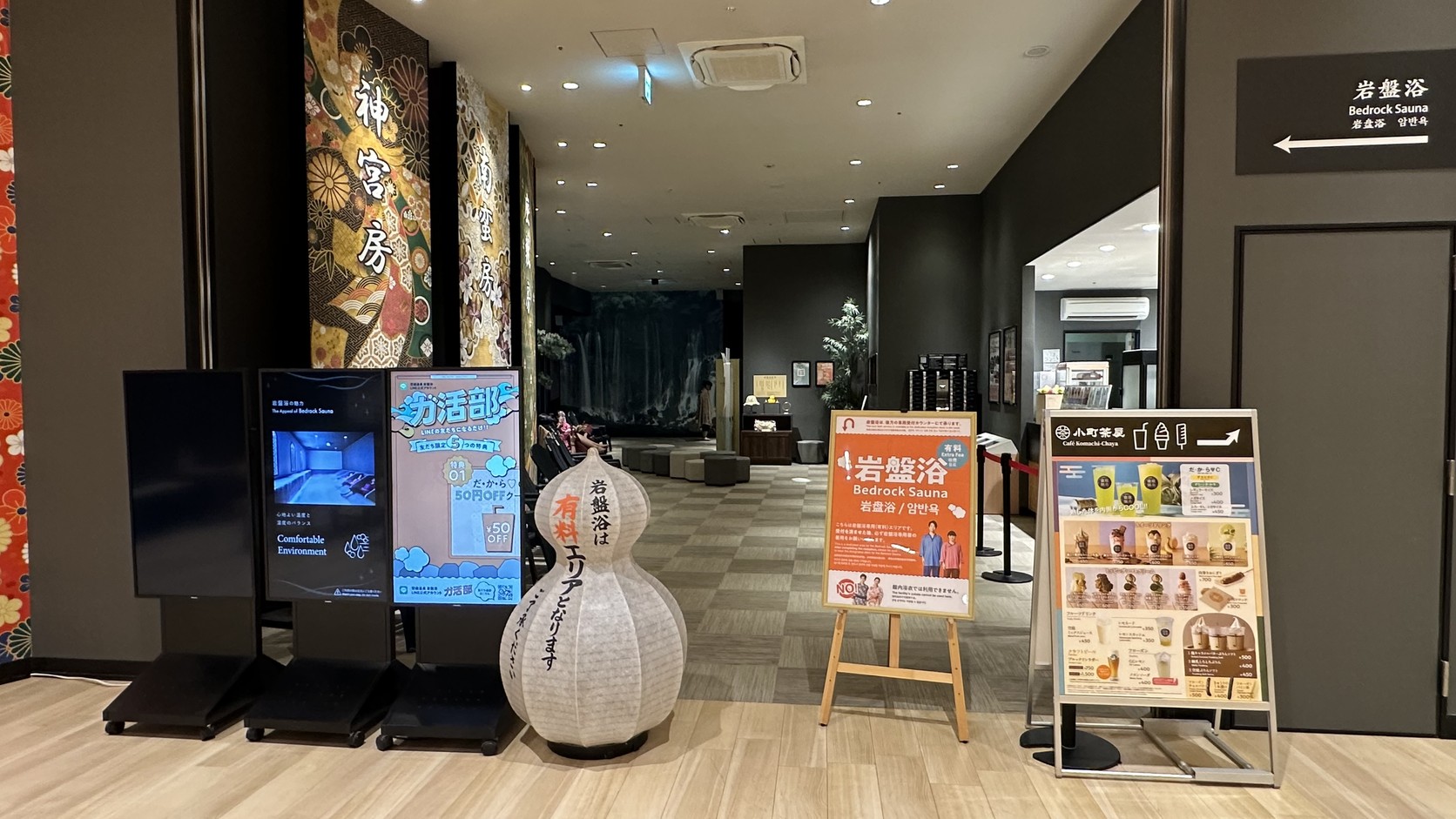 通往岩盤浴與小町茶屋的走道，入口前立著岩盤浴告示牌