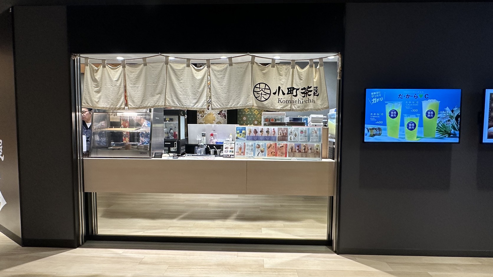 小町茶屋櫃台，門口掛著暖簾並陳列飲料與甜點