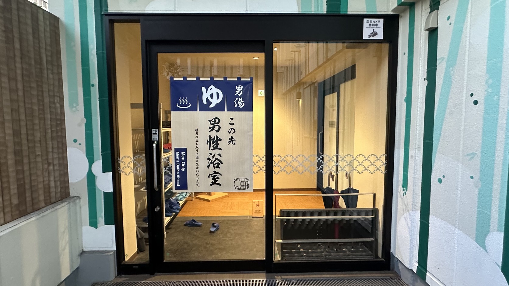 男性浴室入口，掛著寫有「ゆ」與「男湯」的藍色暖簾