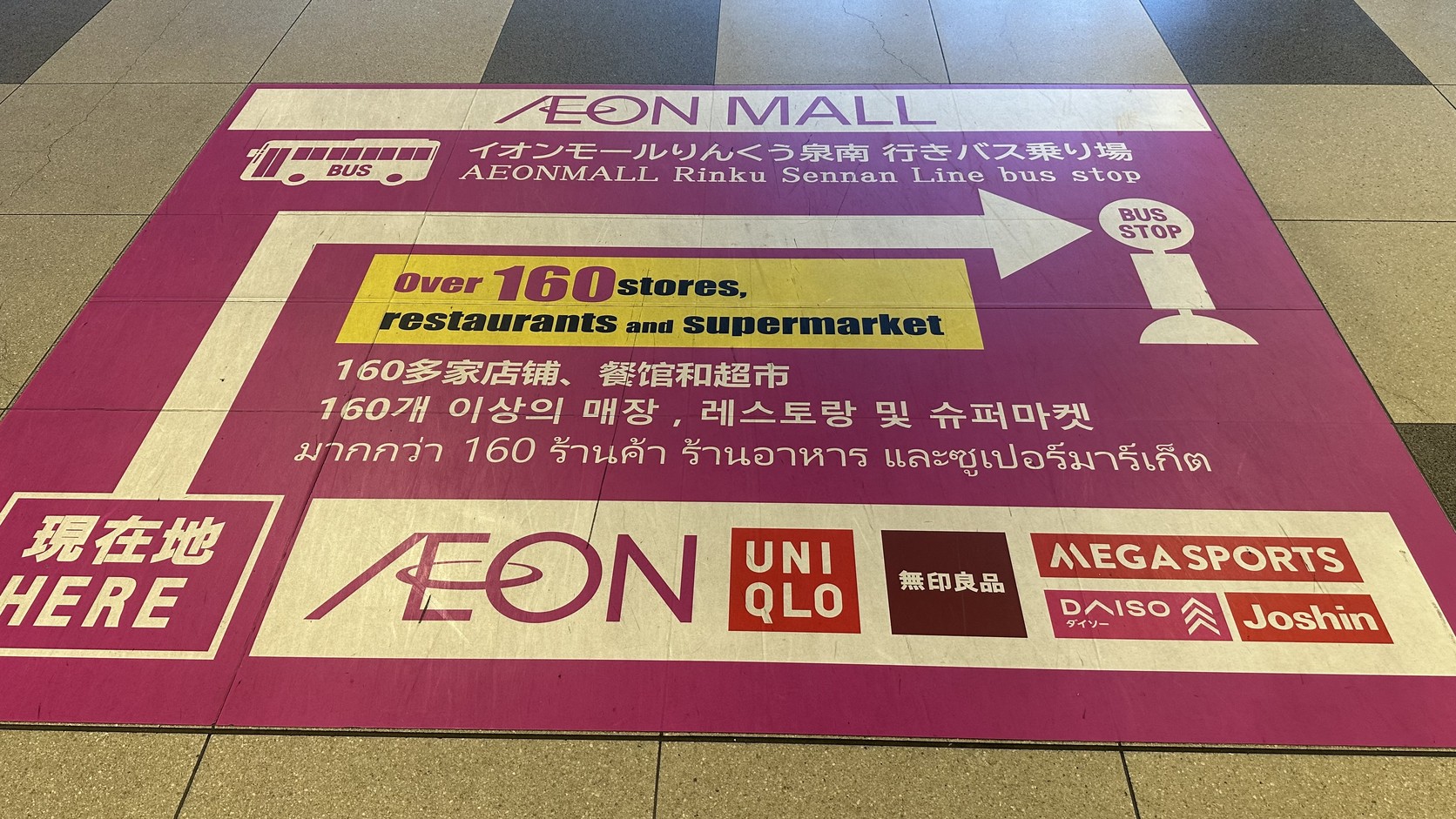 地面上的 AEON MALL 標示，指向前往イオンモールりんくう泉南的巴士乘車處