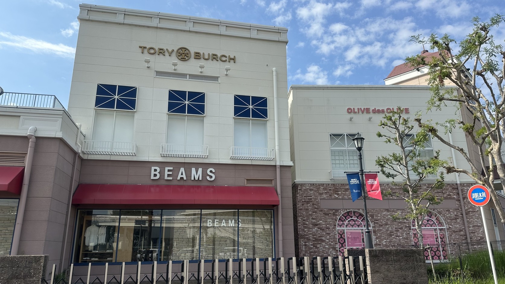 Tory Burch 與 BEAMS 的建築外牆，前方是伸縮圍欄