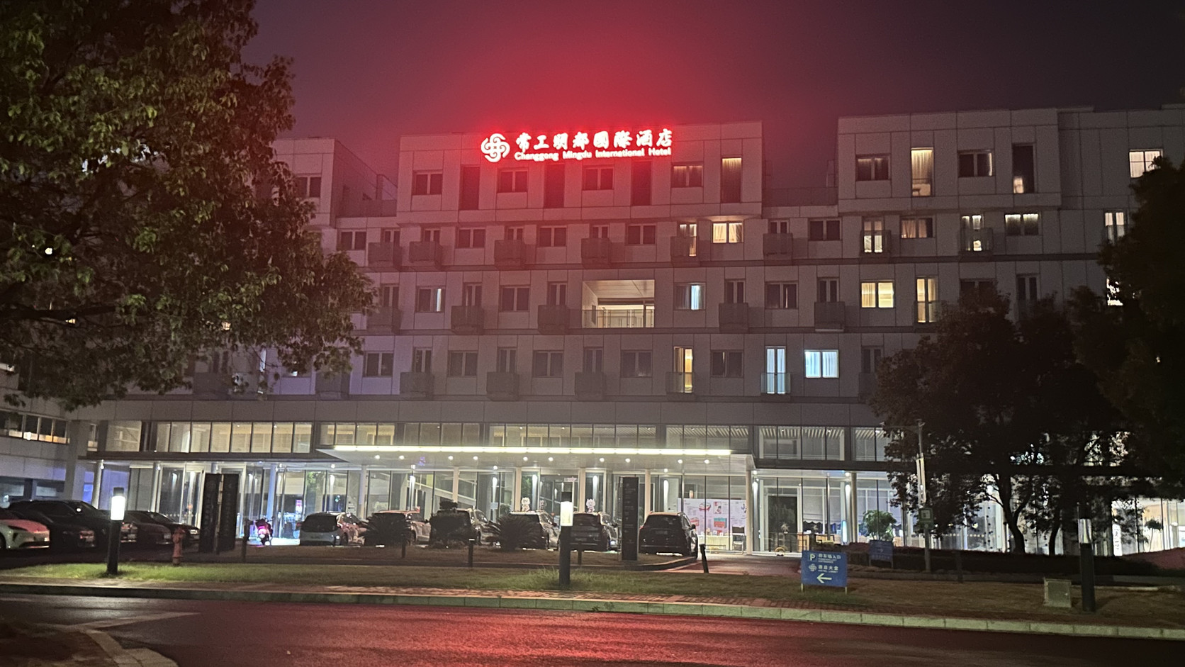 夜間的常工明都國際酒店外觀，建築上方亮著紅色招牌