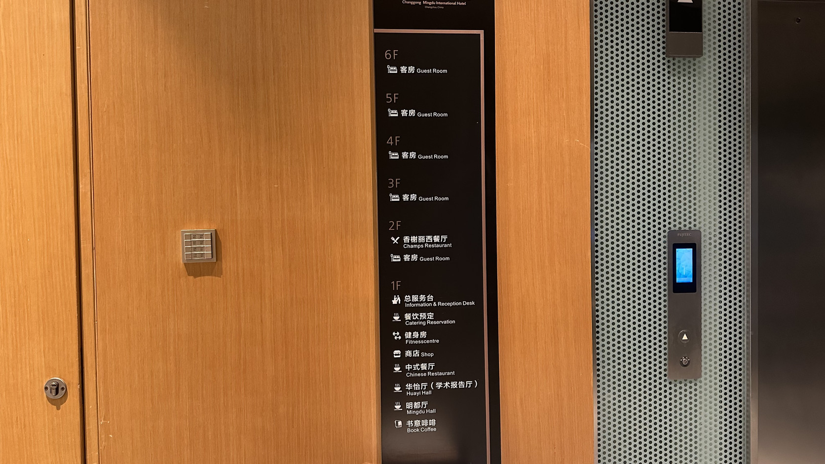 電梯旁的樓層導覽牌，標示一樓的華怡廳（學術報告廳）、明都廳與書意啡啡