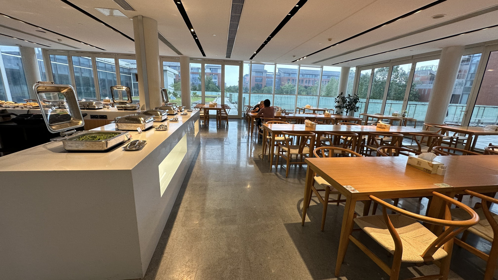 早餐餐廳：落地窗旁的自助餐檯與木質餐桌