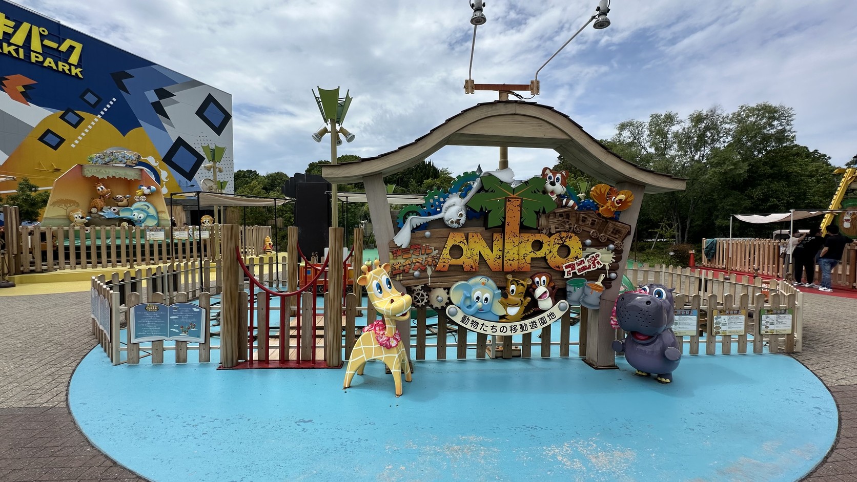 ANIPO的入口招牌「動物たちの移動遊園地」，旁邊有長頸鹿與河馬等動物角色
