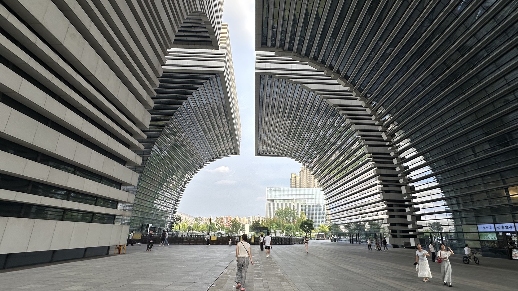 兩棟巨大量體之間形成的拱形開口，遠處可見城市天際線