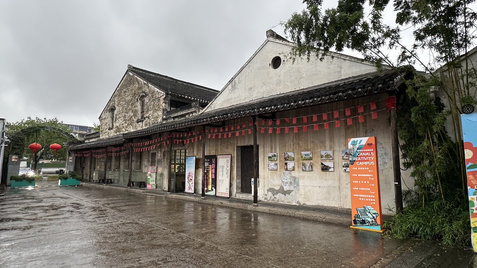 老廠房活化後的街區景觀，屋簷下掛著紅色燈籠與展覽海報