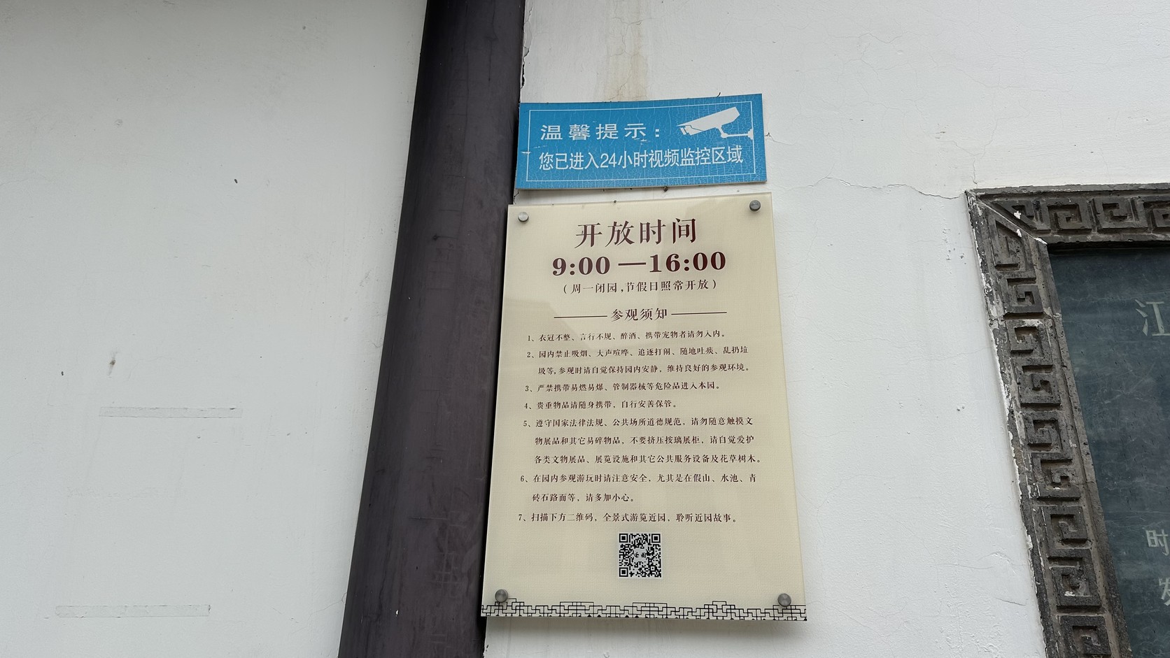 近園入口牆面的開放時間牌，標示 9:00—16:00，週一閉園，節假日照常開放