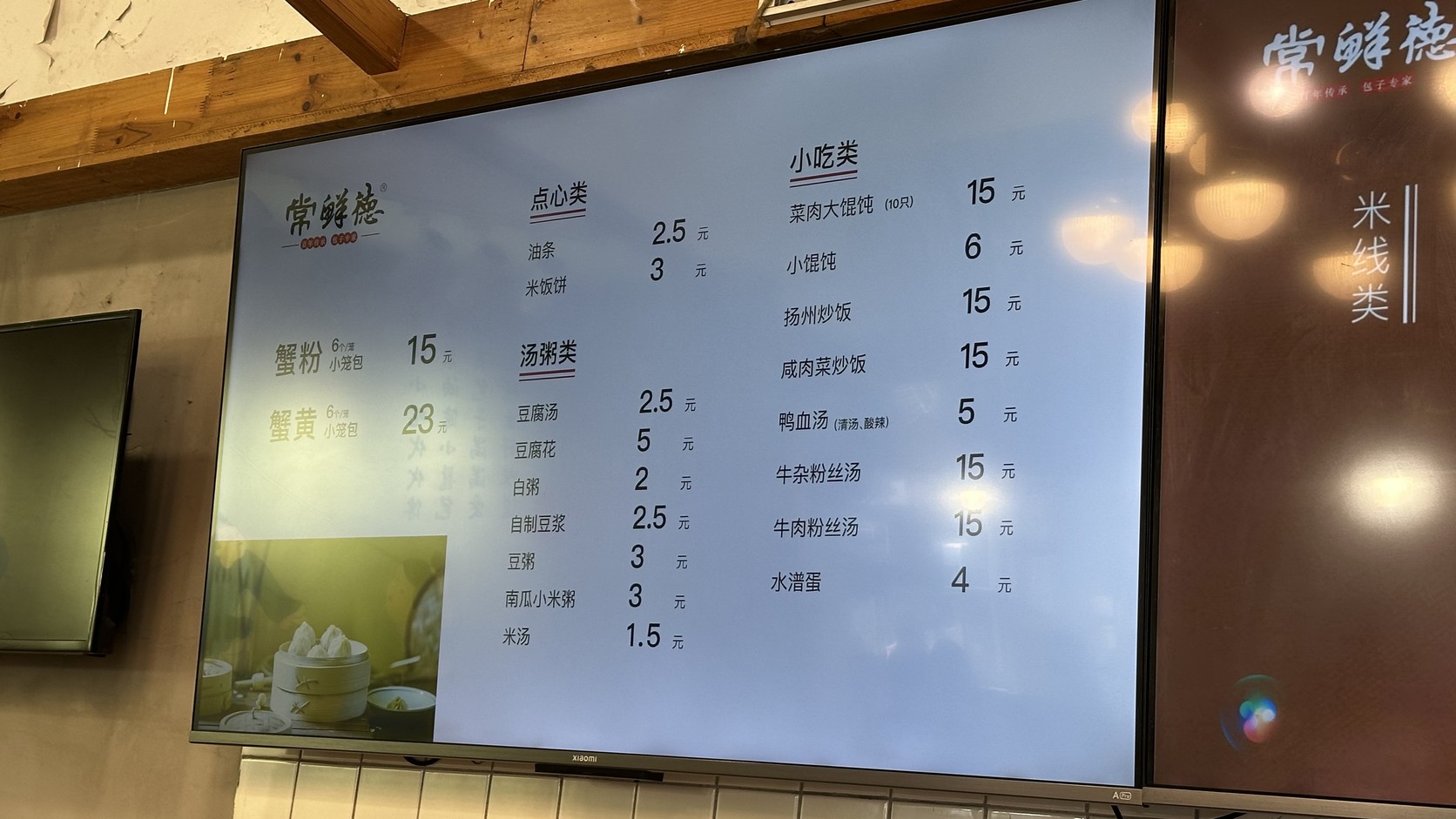 店內電子菜單：蟹粉小籠包6個一籠15元、蟹黃小籠包6個一籠23元，另有點心、湯粥與小吃價目
