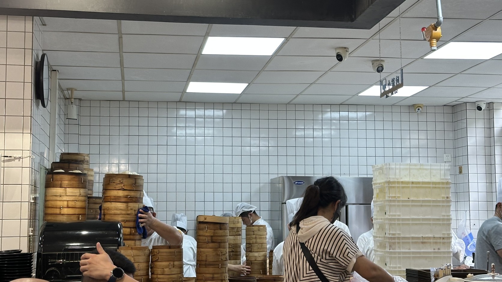 小籠包製作區：疊起的蒸籠與多位師傅忙著出餐
