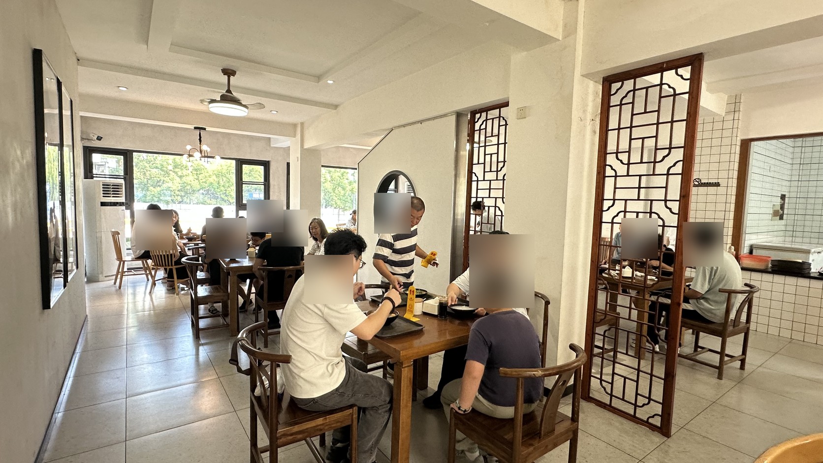 二樓座位區，木桌椅、格柵隔屏與大片窗戶