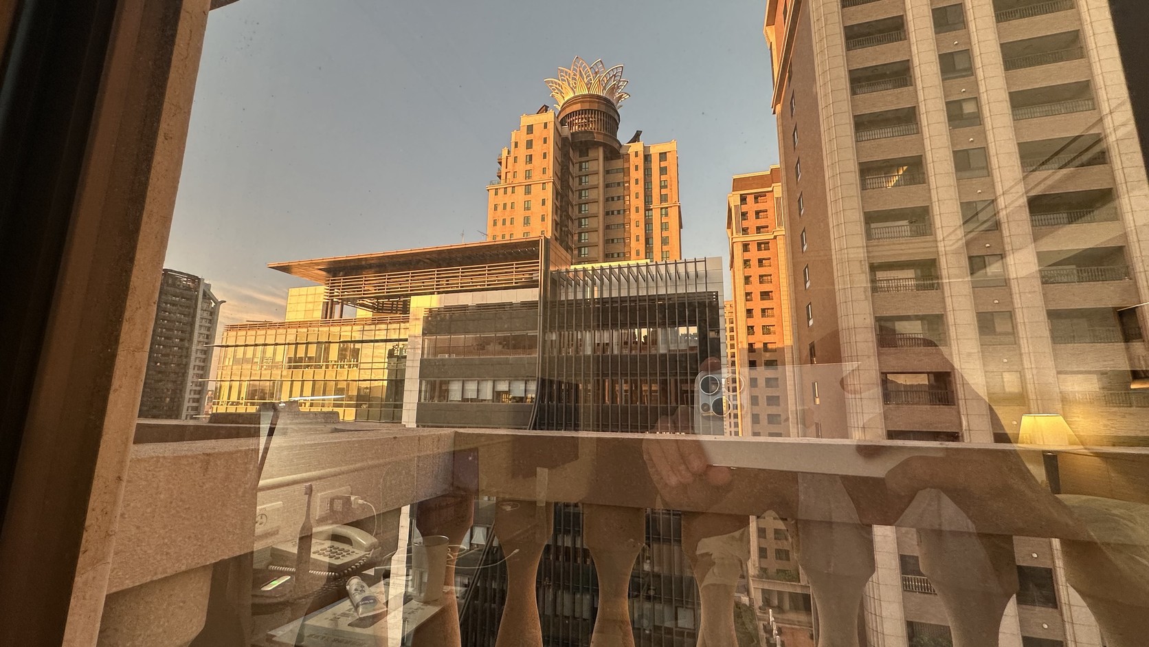清晨從 15 樓客房窗戶望出去的桃園市區景色，遠處高樓頂端有花冠造型裝飾