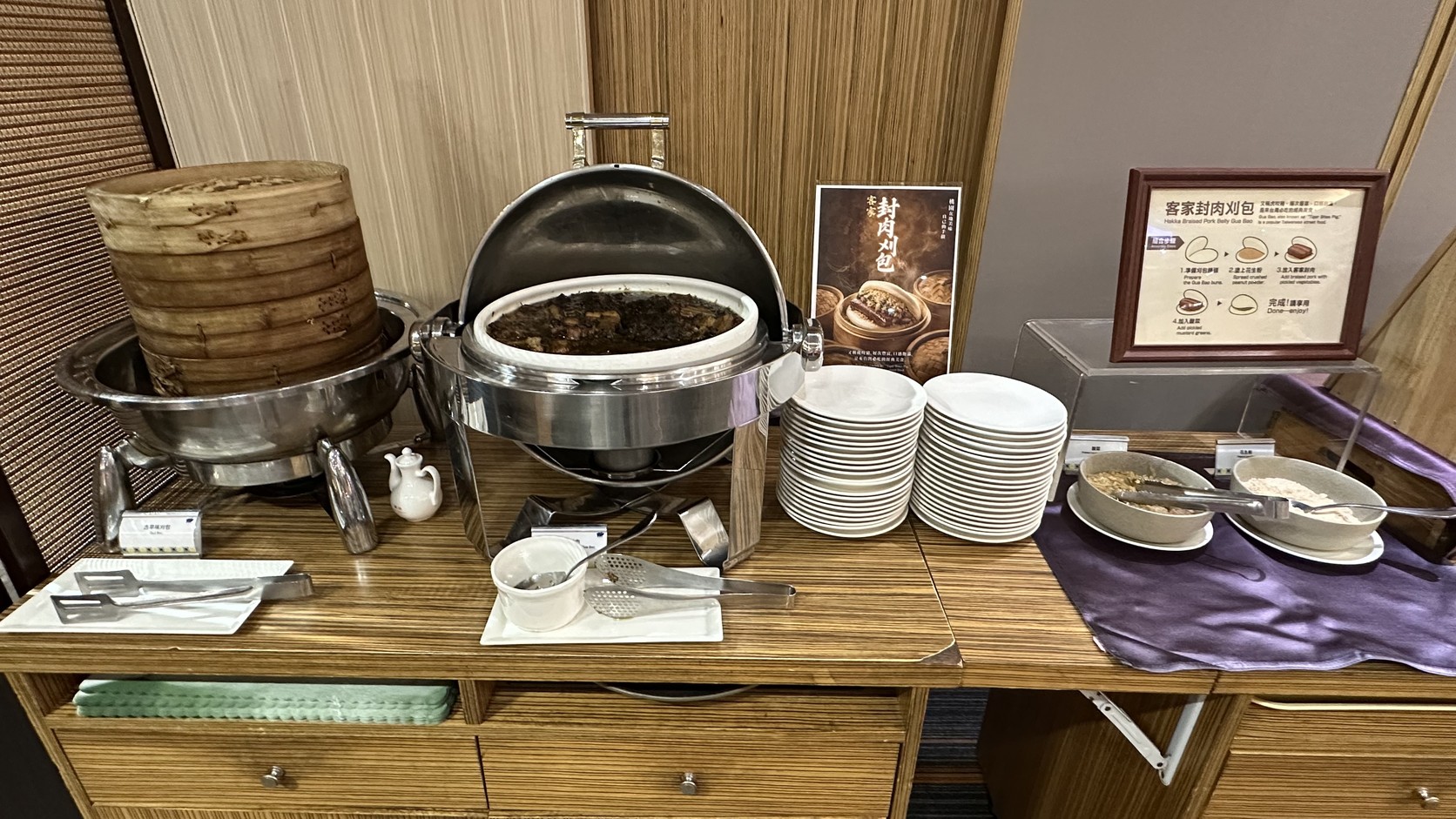 早餐餐檯上的蒸籠刈包、封肉保溫鍋與刈包說明牌