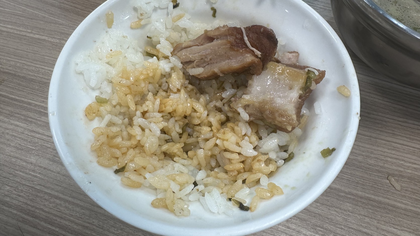 吃到一半的爌肉飯碗，白飯混著淡褐色滷汁，旁邊剩下幾塊爌肉