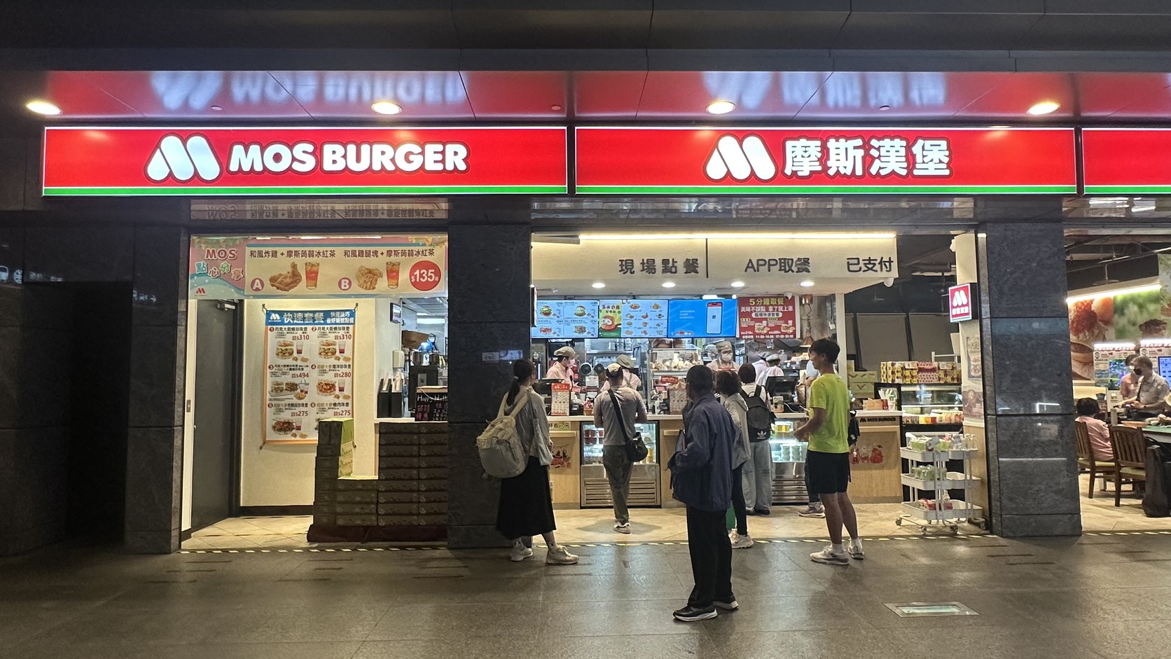 摩斯漢堡高鐵台中店店面：紅色「MOS BURGER」與「摩斯漢堡」招牌，櫃檯上方分為現場點餐與APP取餐區