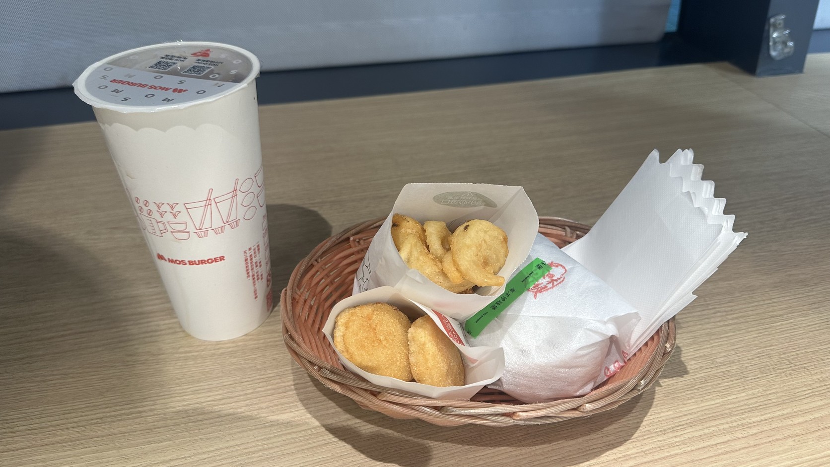 藤籃中的205元海洋月薯套餐：大杯冰紅茶、4塊摩斯雞塊、月亮薯條與包著白紙的珍珠堡