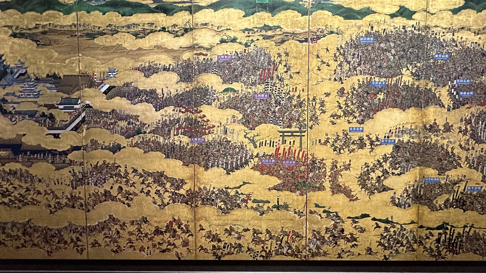 五樓《大坂夏之陣圖屏風》的放大展示畫面，金色雲霞間佈滿軍隊與城郭