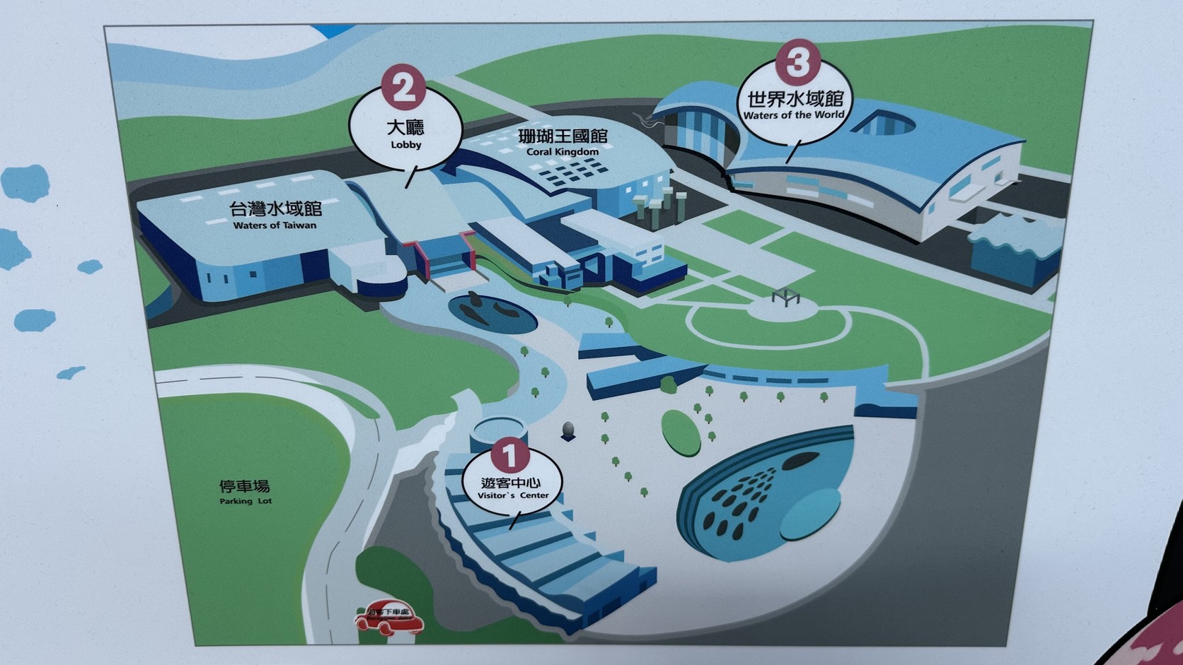 海生館園區導覽圖，標示遊客中心、大廳、臺灣水域館、珊瑚王國館與世界水域館的位置