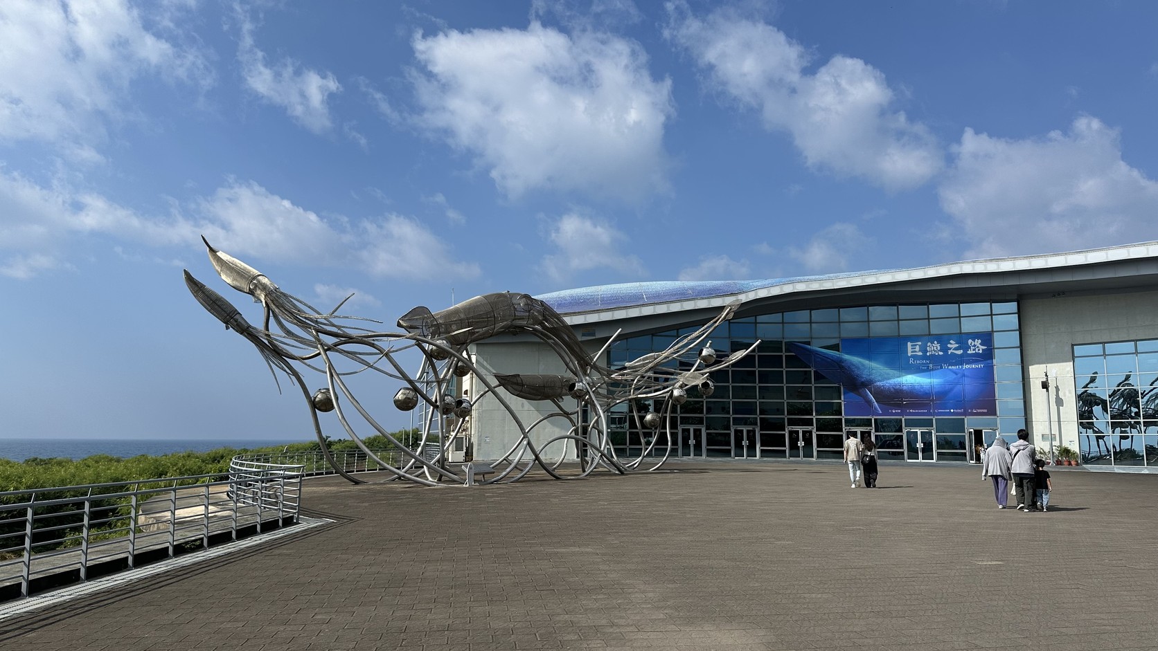世界水域館前廣場的銀色金屬海洋生物裝置與「巨鯨之路」大布條