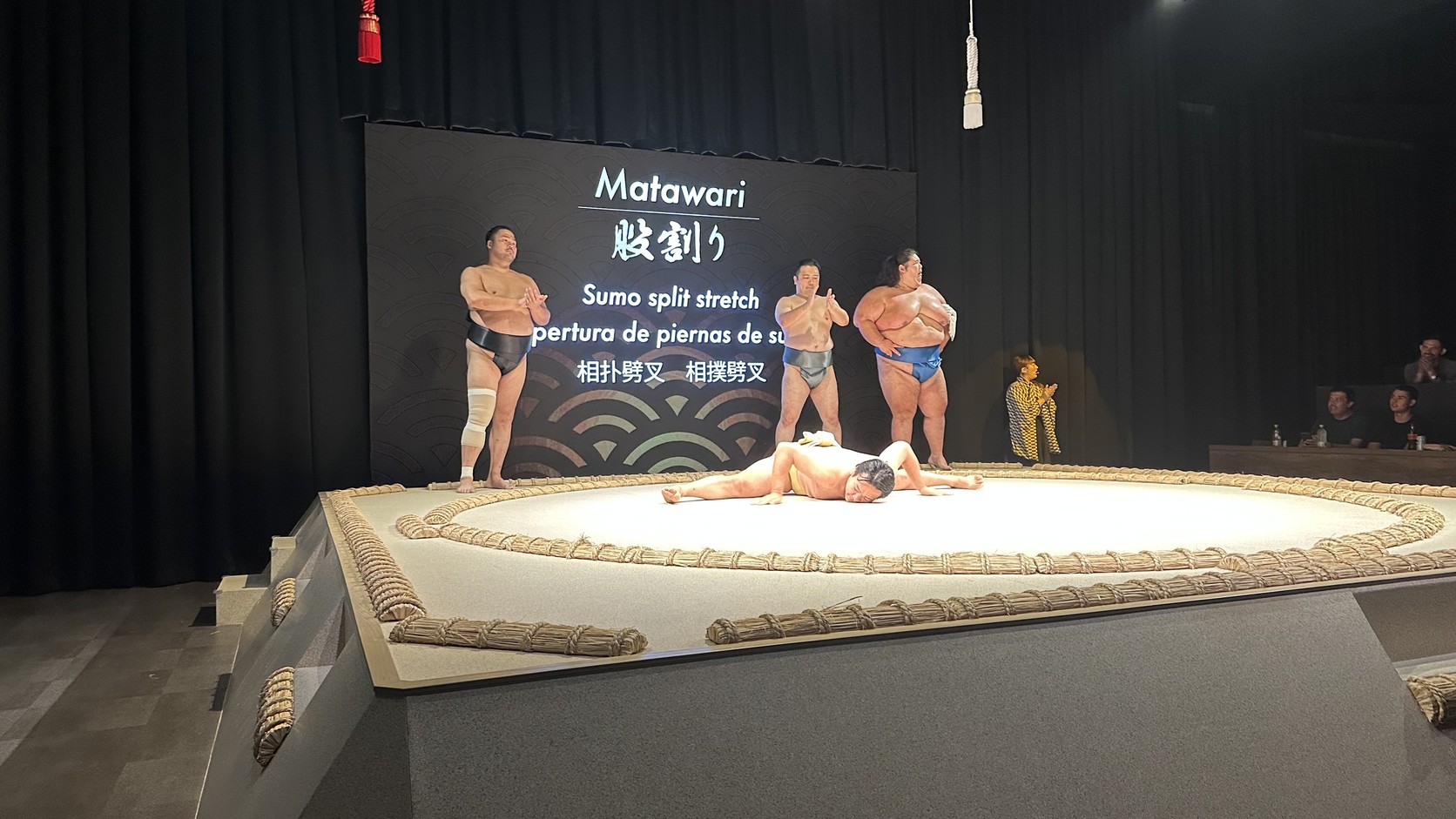 力士示範股割り，雙腿大幅張開、上半身貼近地面