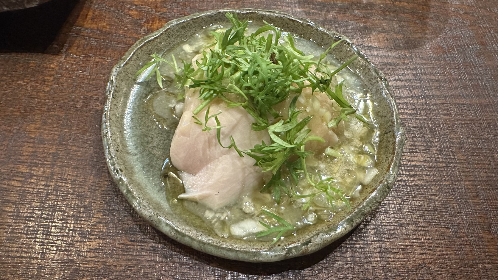 自家製發酵蒸雞：厚片雞肉淋上白色醬汁，鋪著翠綠葉菜，盛在綠釉陶盤中